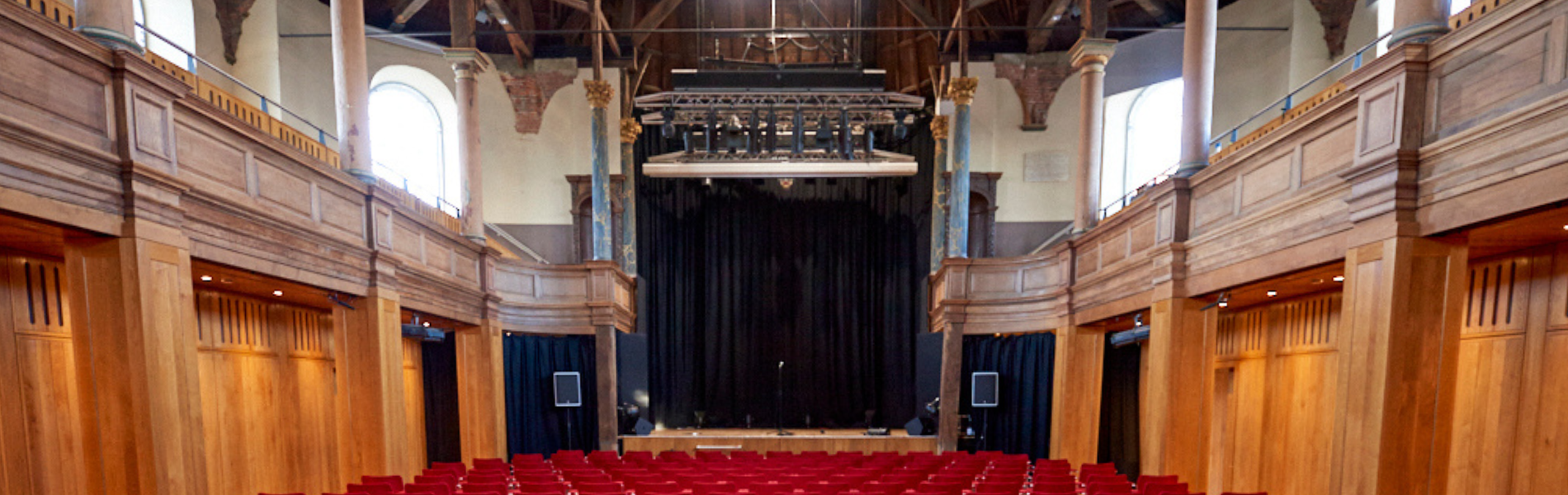 An image of the Auditorium at St Georges with red seats and an empty stage